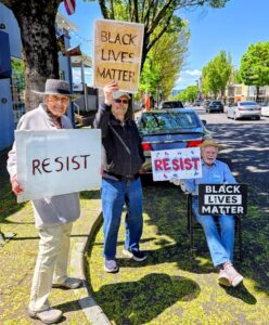 Westminster members holding "Black Lives Matter" and "Resist" signs